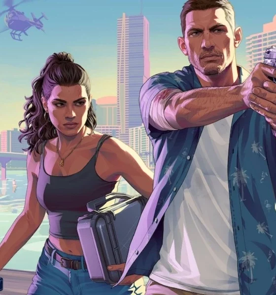 Capture d'écran de GTA 6 montrant deux personnages armés sur un quai, devant une ville côtière moderne avec gratte-ciel et palmiers. La femme tient une mallette et une arme, tandis que l’homme pointe un pistolet vers l’avant, avec un hélicoptère en vol à l’arrière-plan.